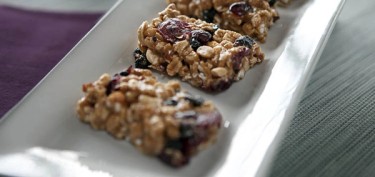three granola bars made of nuts and raisins.