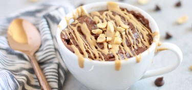 a chocolate mug cake drizzled with peanut butter.