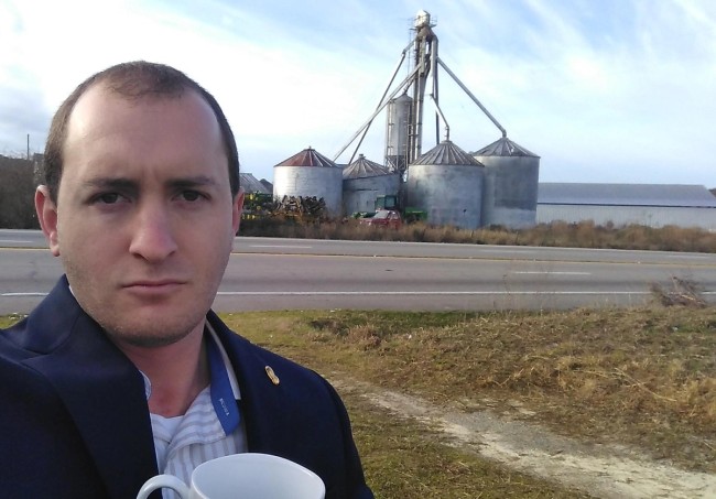 a selfie of James Harrell with 4 silos on the background