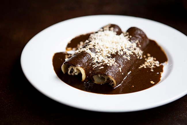 a plate of pancakes covered in molé sauce