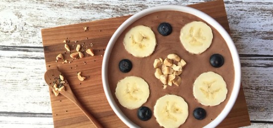 A bowl of chocolate smoothie with bananas and blueberries.