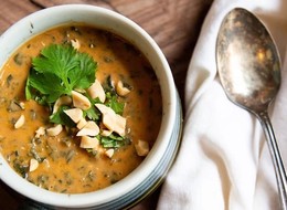 a bowl of stew with peanuts on top of it.