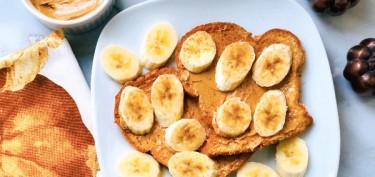two french toast with peanut butter spread on top and banana slices.