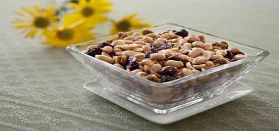 Peanuts and raisins in a glass bowl.