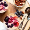 two glasses of creamy oatmeal with berries on top.