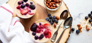 two glasses of creamy oatmeal with berries on top.
