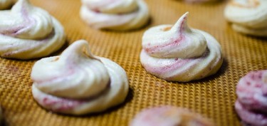 a tray of meringues with a soft strawberry color.