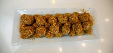 A plate full of balls made of banana and peanut butter.