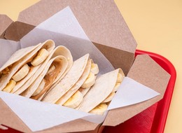 A delighful dish featuring a warm tortilla filled with creamy peanut butter, sliced bananas and a drizzle of honey.