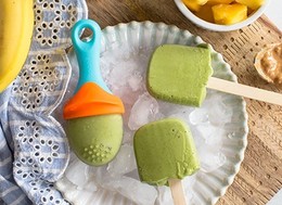 ice cream made of spinach in wooden sticks and baby popsicles molds .