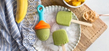 ice cream made of spinach in wooden sticks and baby popsicles molds .