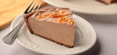 slice of soft chocolate cheesecake with peanut bits on top.