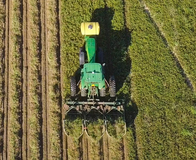  An aerial view of a tractor in a field.