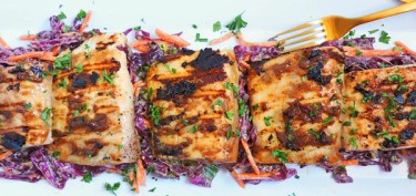 grilled fish fillets with shredded red cabbage and carrots.