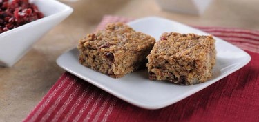two squared sized bars made of oatmeal and dried cranberries.