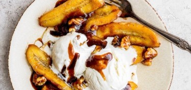 delicious banana dessert topped with ice cream and nuts.