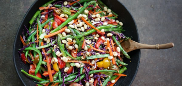 a pan filled with sliced vegetables and peanuts.