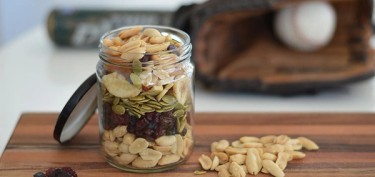 a glass jar filled with nuts and raisins.