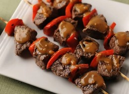 beef and red pepper skewers glazed in dark sauce.