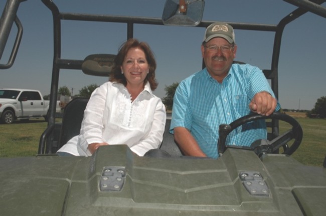 a man and woman smiling inside a open jeep