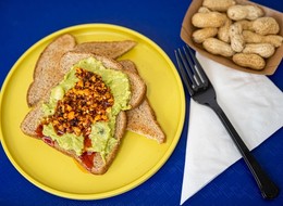 A vibrant dish that combines creamy avocado spread on toasted bread, topped with a spicy and crunch salsa.