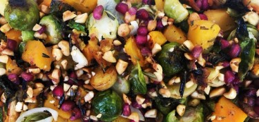a mixture of roasted vegetables, nuts and pomegranate seeds.