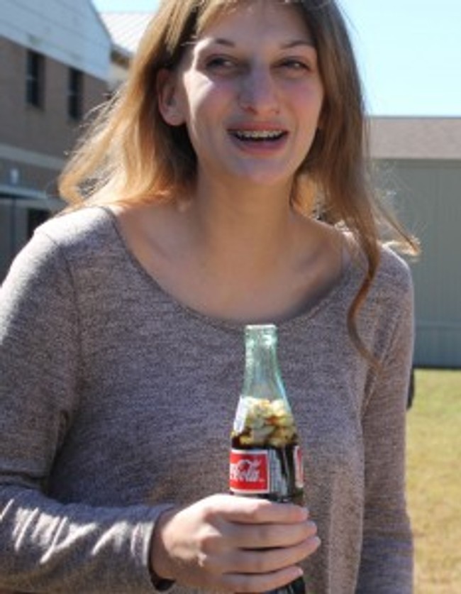 girl holding a coke with peanuts