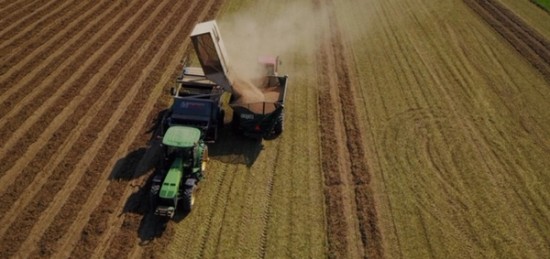 Aerial view of a combine harvester in a field.