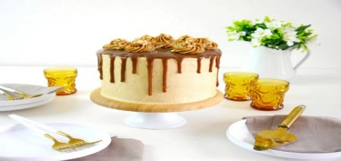 a cake decorated with caramel sauce and peanut frosting on top.