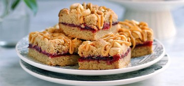 peanut bars with cranberry jam in the middle glazed with creamy peanut butter.