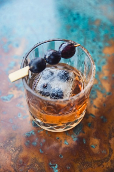 old fashioned drink with berries on top