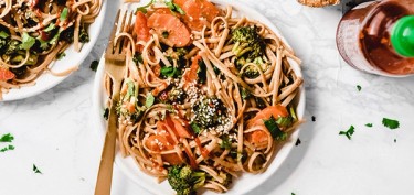 plate of pasta with broccoli and carrots.
