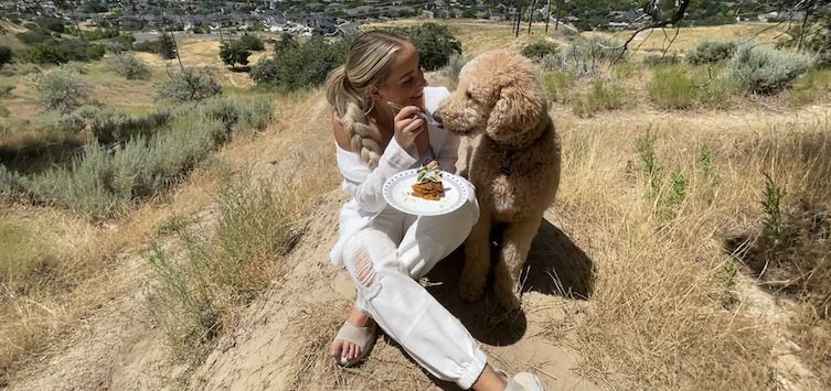 a girl eating waffles with her dog