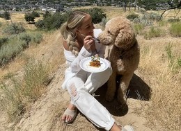 a girl eating waffles with her dog