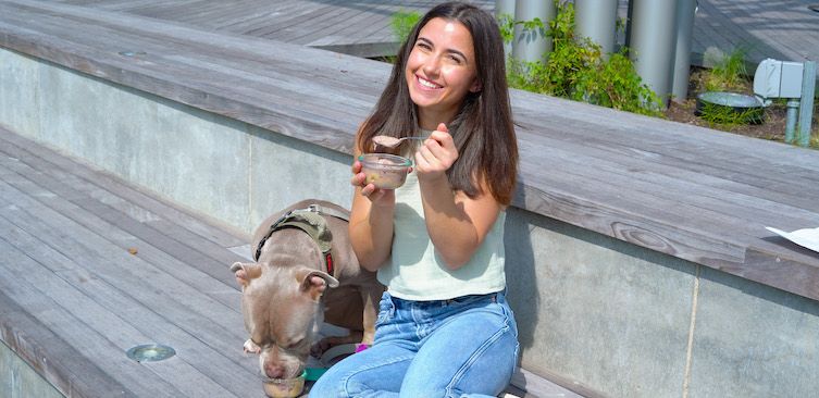 girl sharing ice cream with her dog
