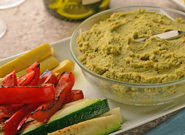 bowl of edamame hummus and roasted vegetables on the side.