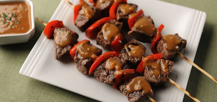beef and red pepper skewers glazed in dark sauce.