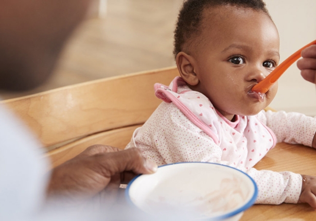 a cute baby being spoon fed