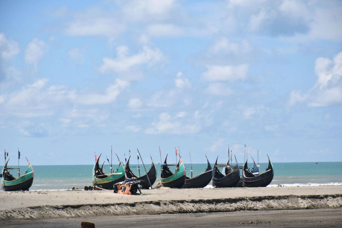 Long sandy beach at Cox's Bazar with gentle waves at sunset