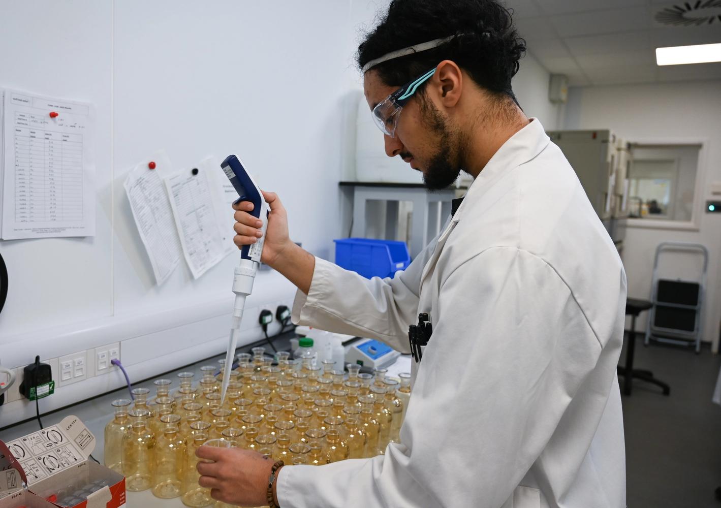 Photograph of a technician sampling water samples in bottles 