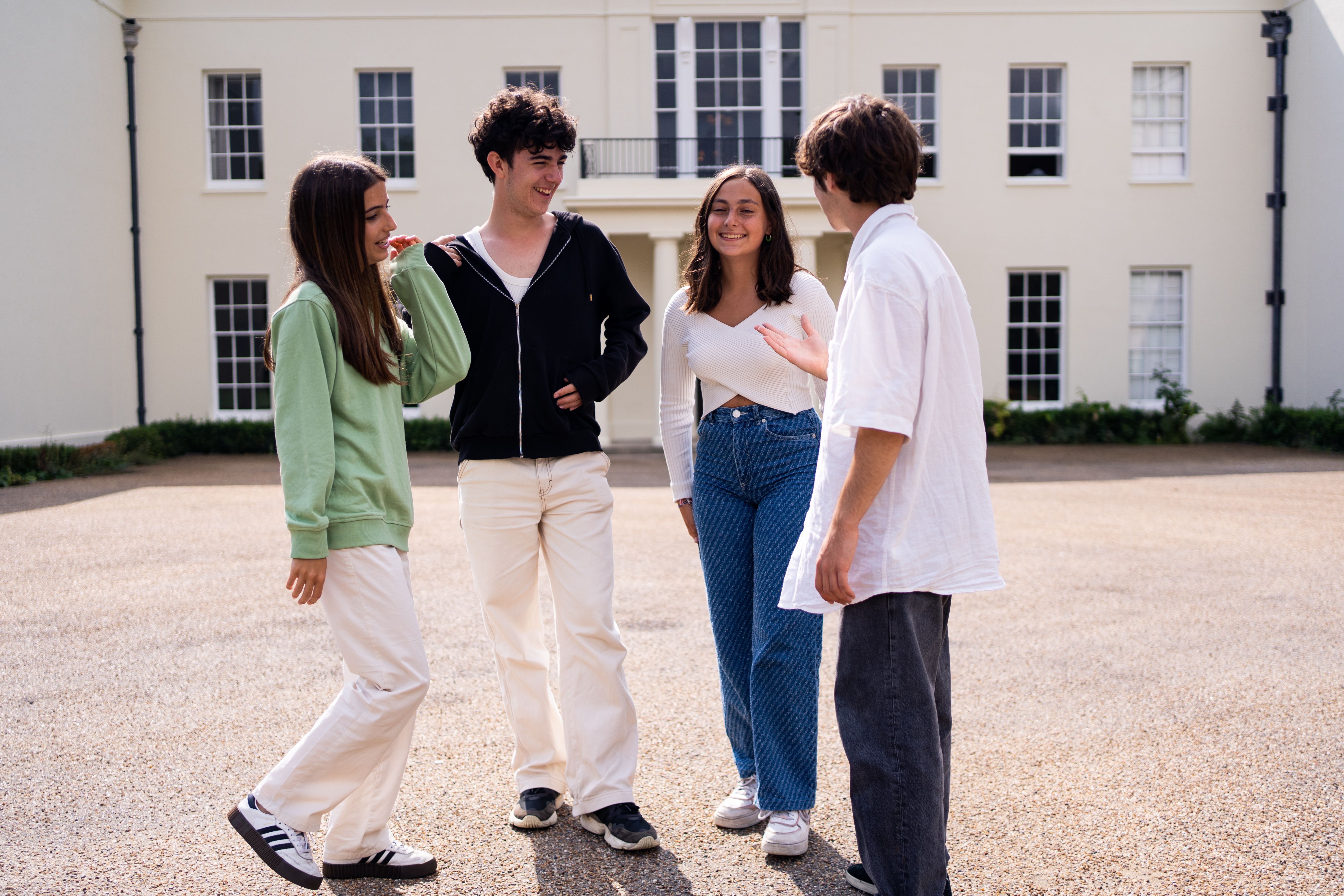 Group of junior students outside building talking