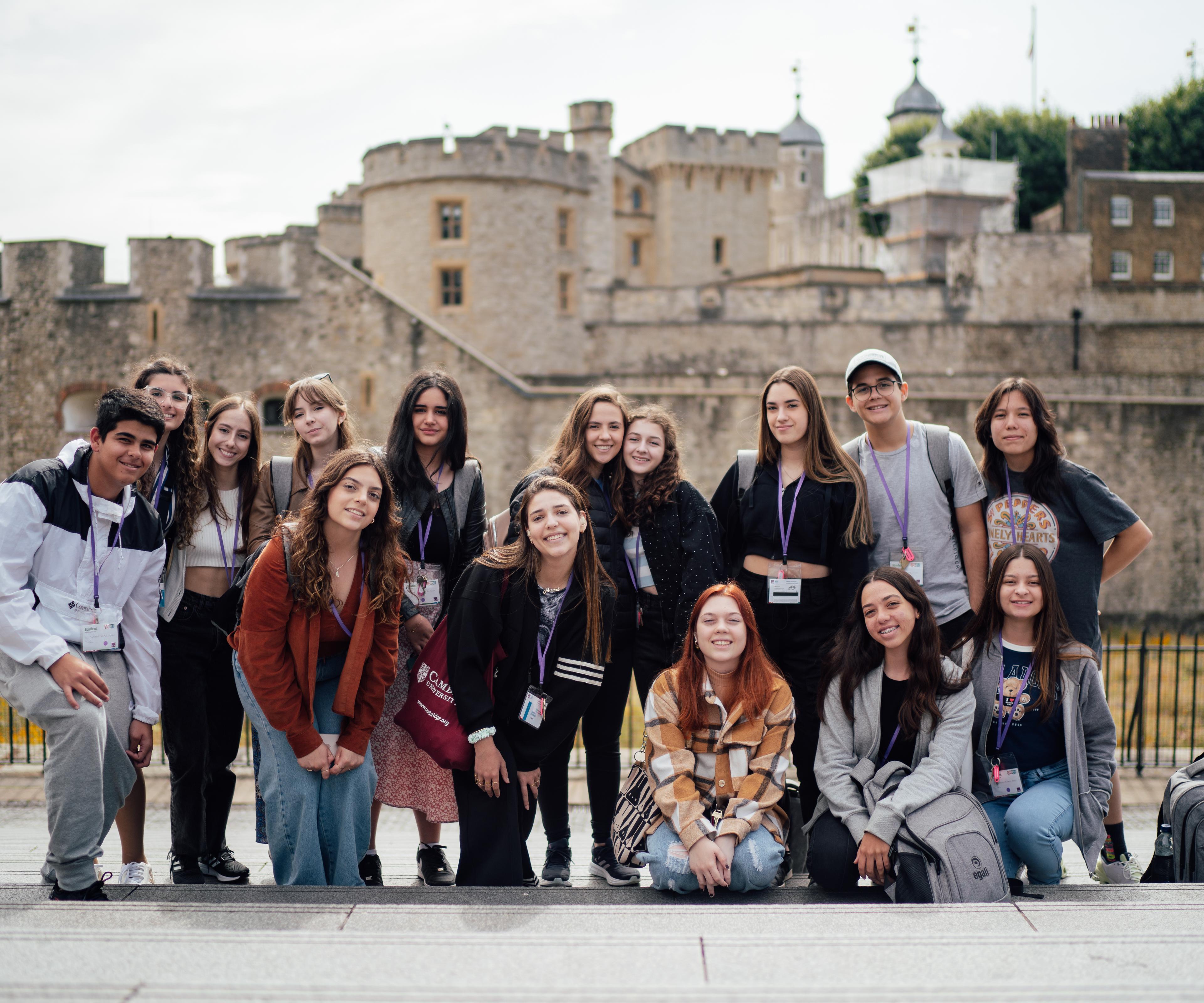 Group of teenagers outside Tower of London posing for camera