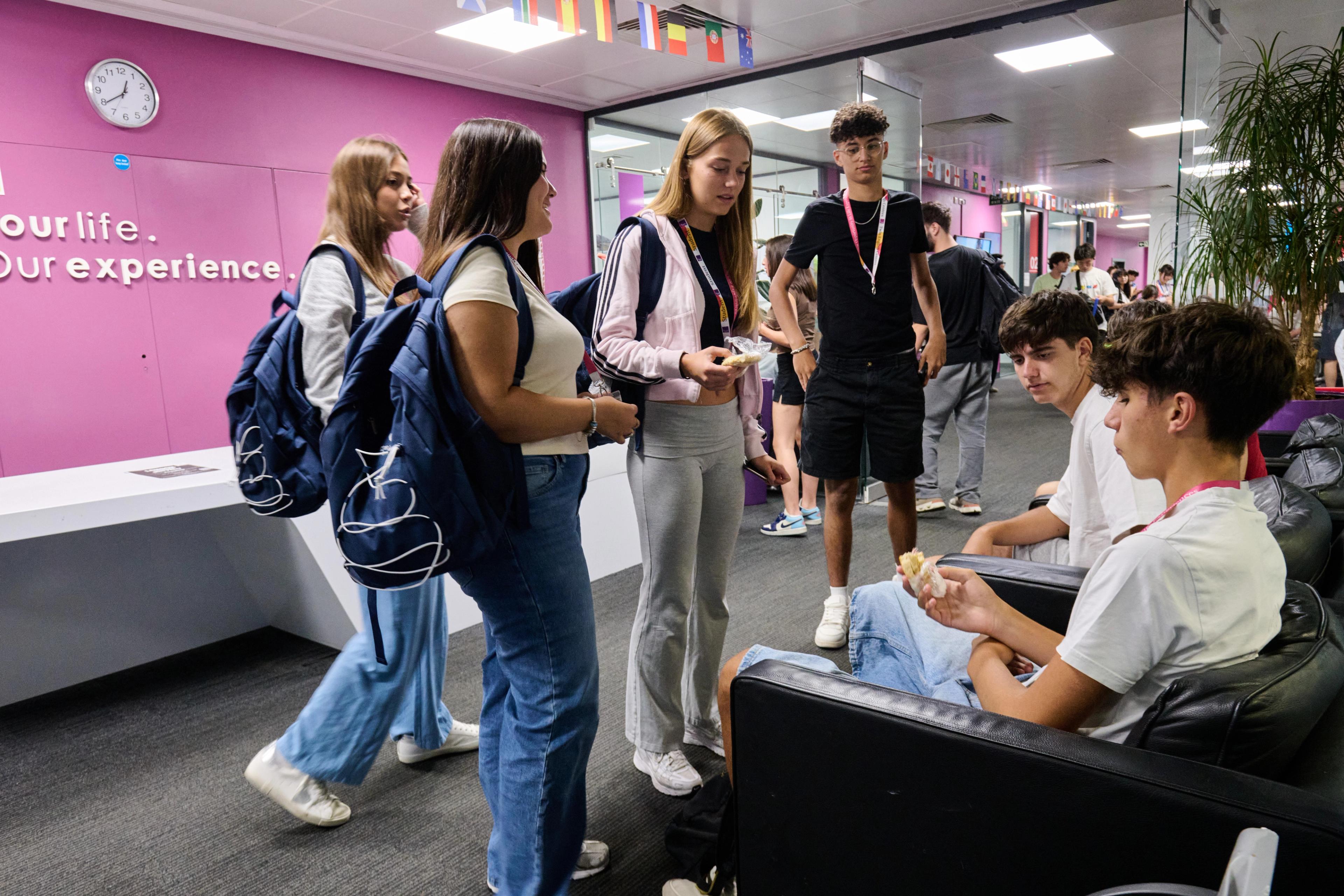 Group of international students talking in the reception area of an English language school in London