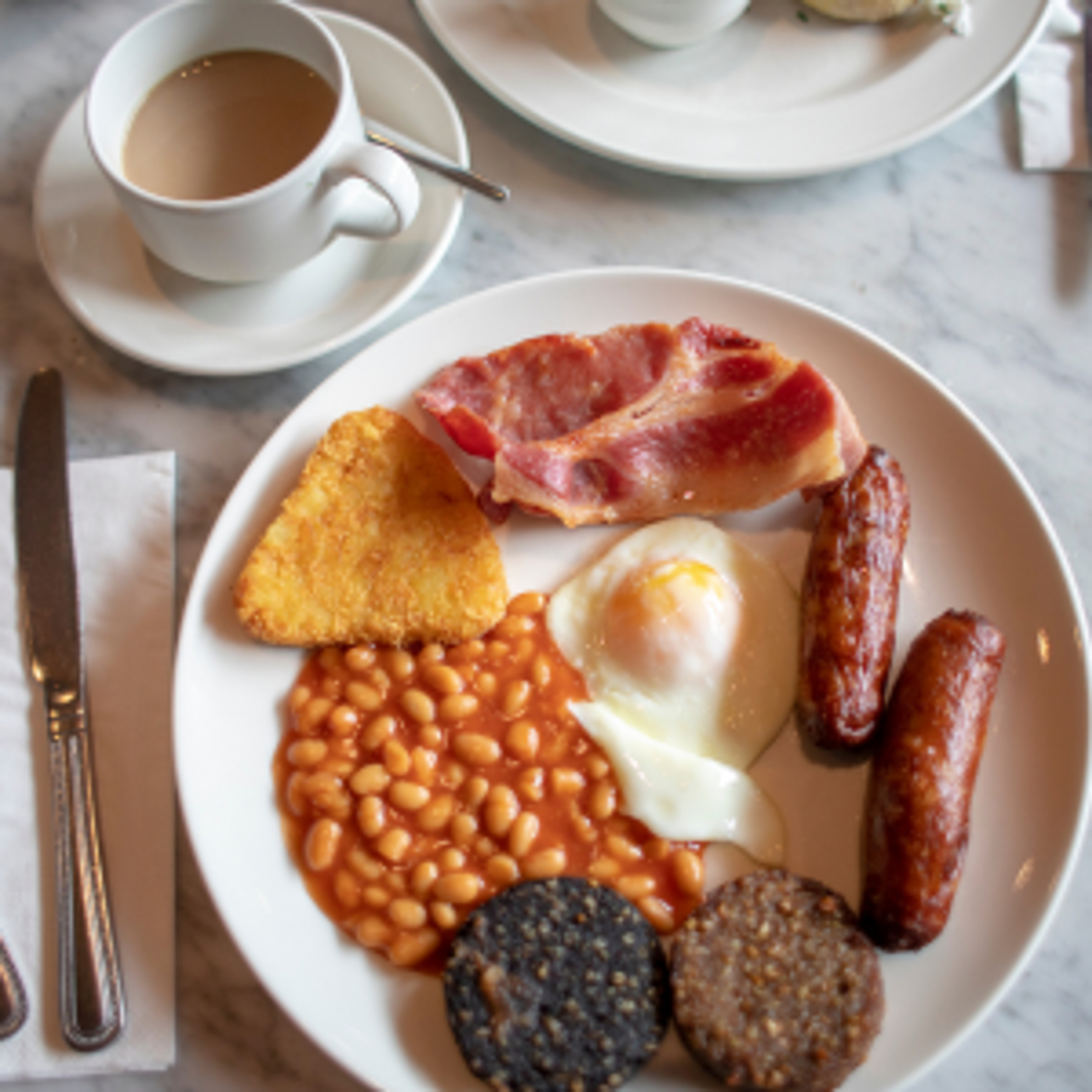 A traditional Irish Breakfast with delicious bacon, sausage, hash browns, and black and white pudding