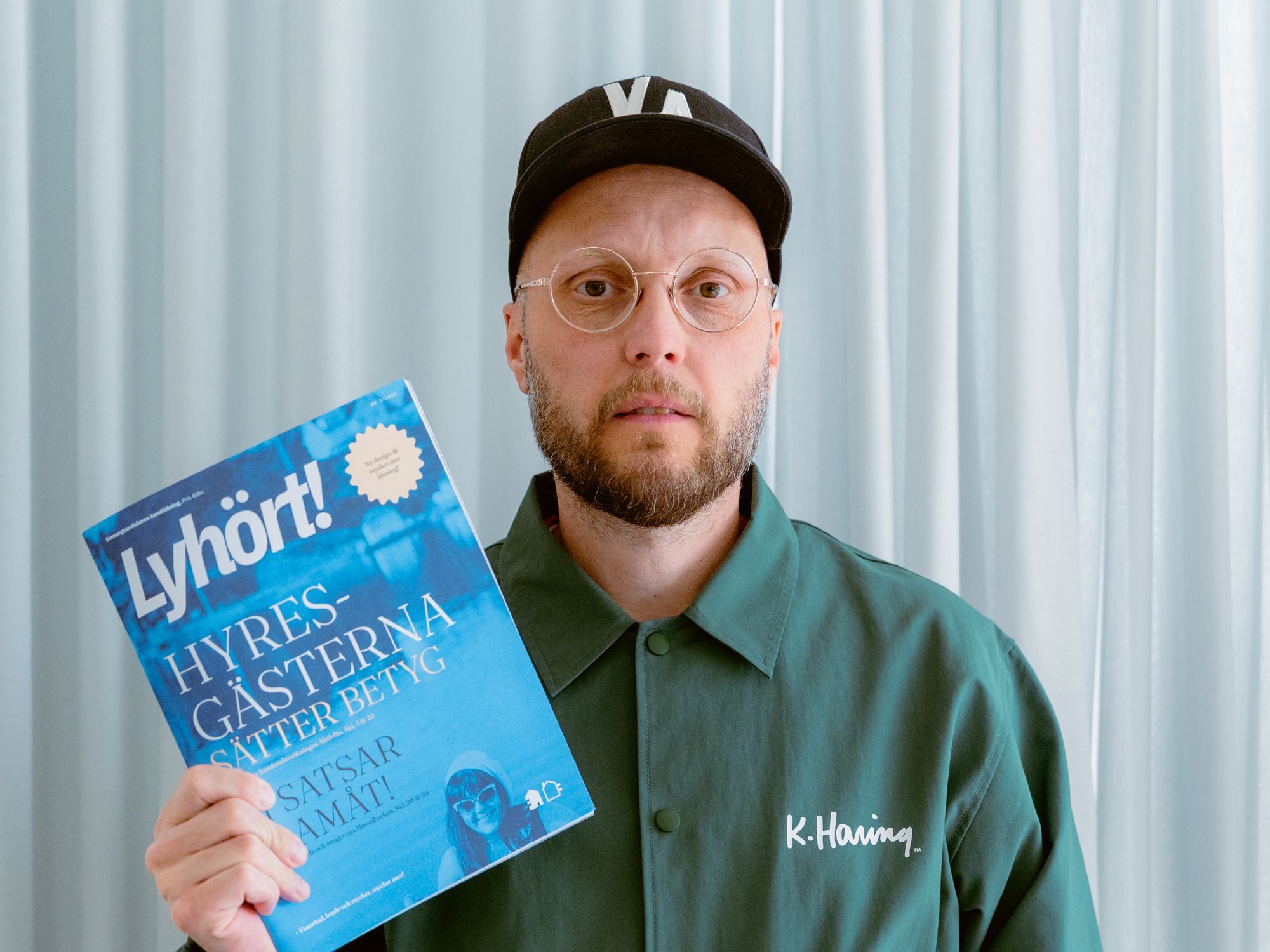 En person håller upp framsidan av kundtidningen Lyhört