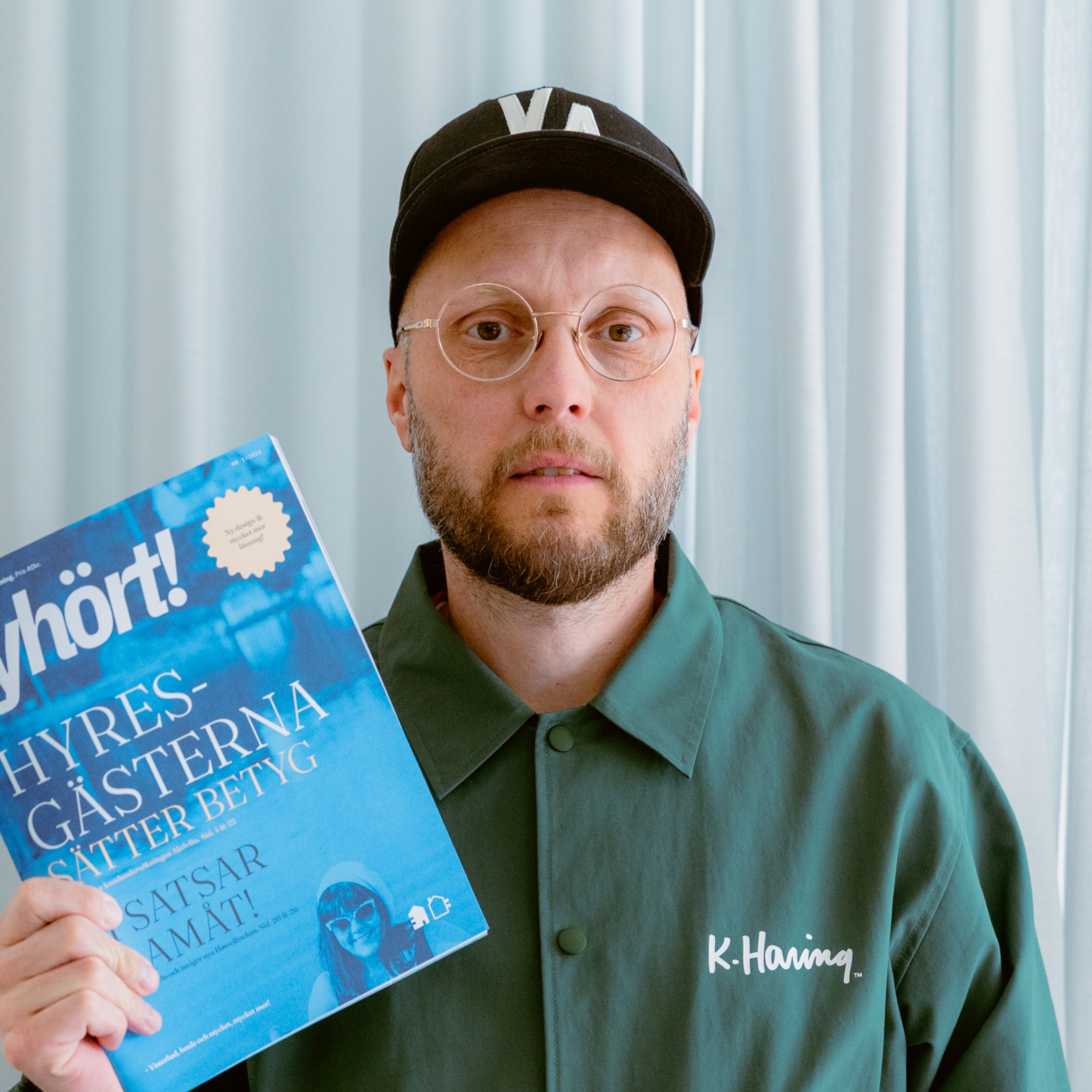 En person håller upp framsidan av kundtidningen Lyhört