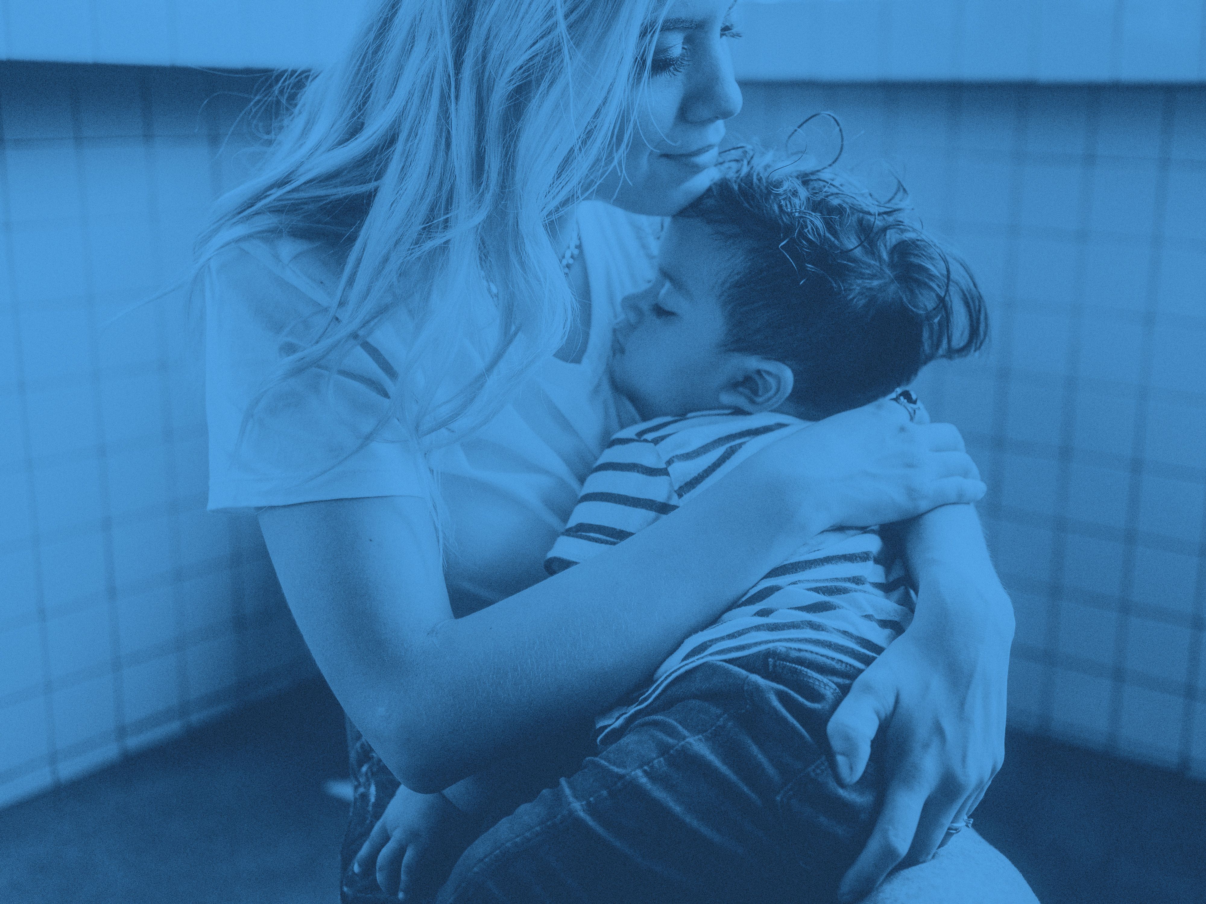 Ett barn vilar i sin mammas famn