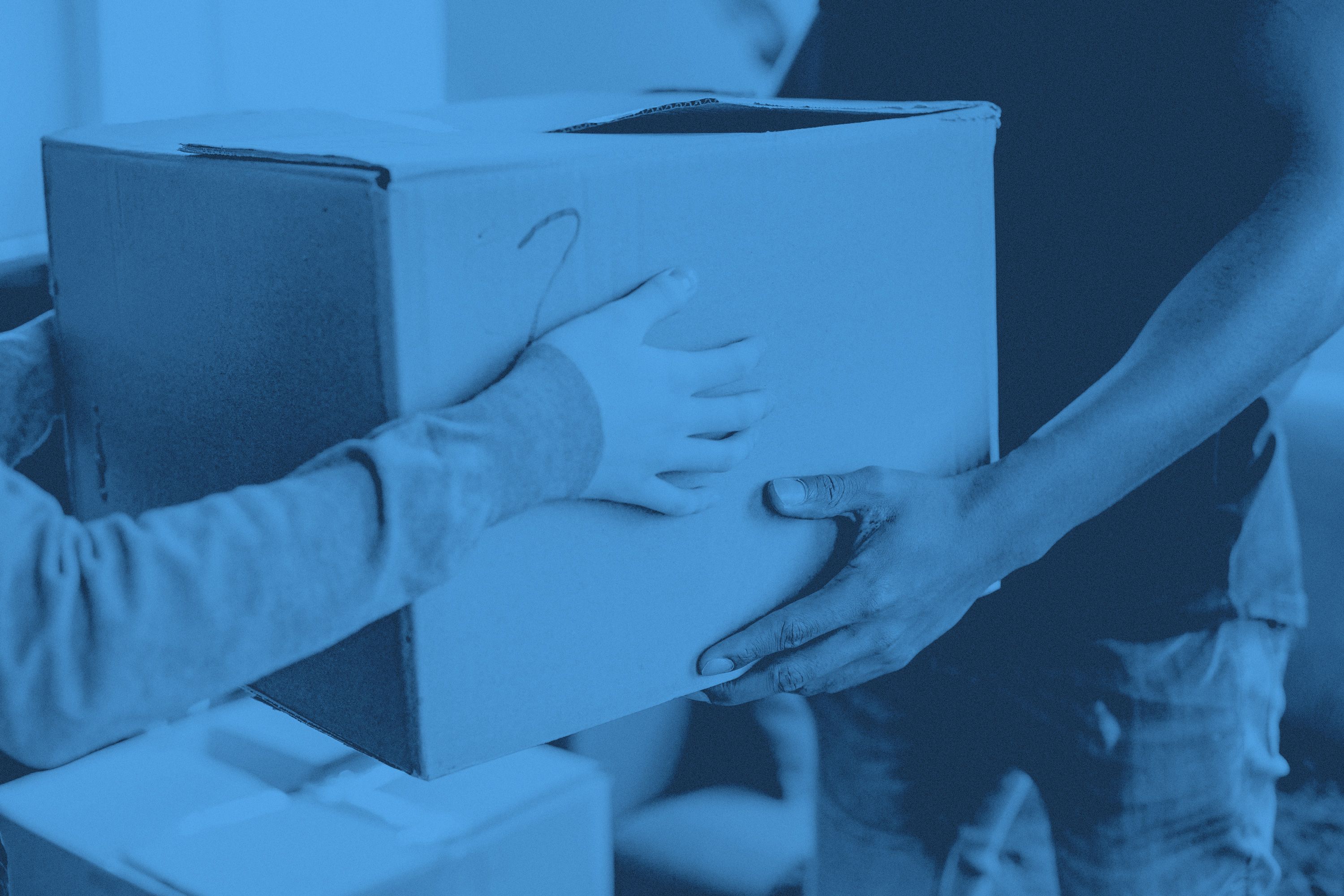 Två personer håller i en flyttkartong