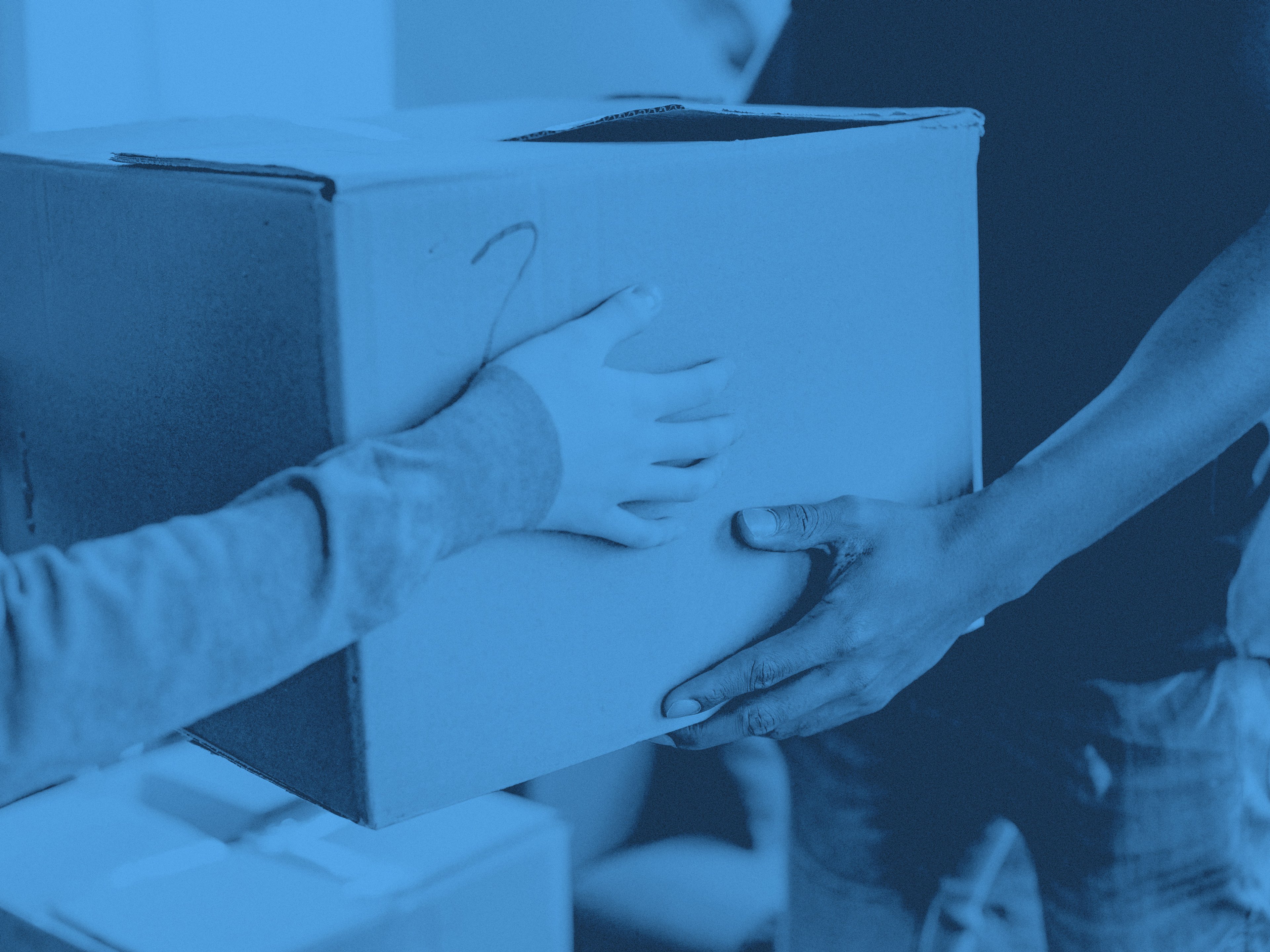 Två personer håller i en flyttkartong