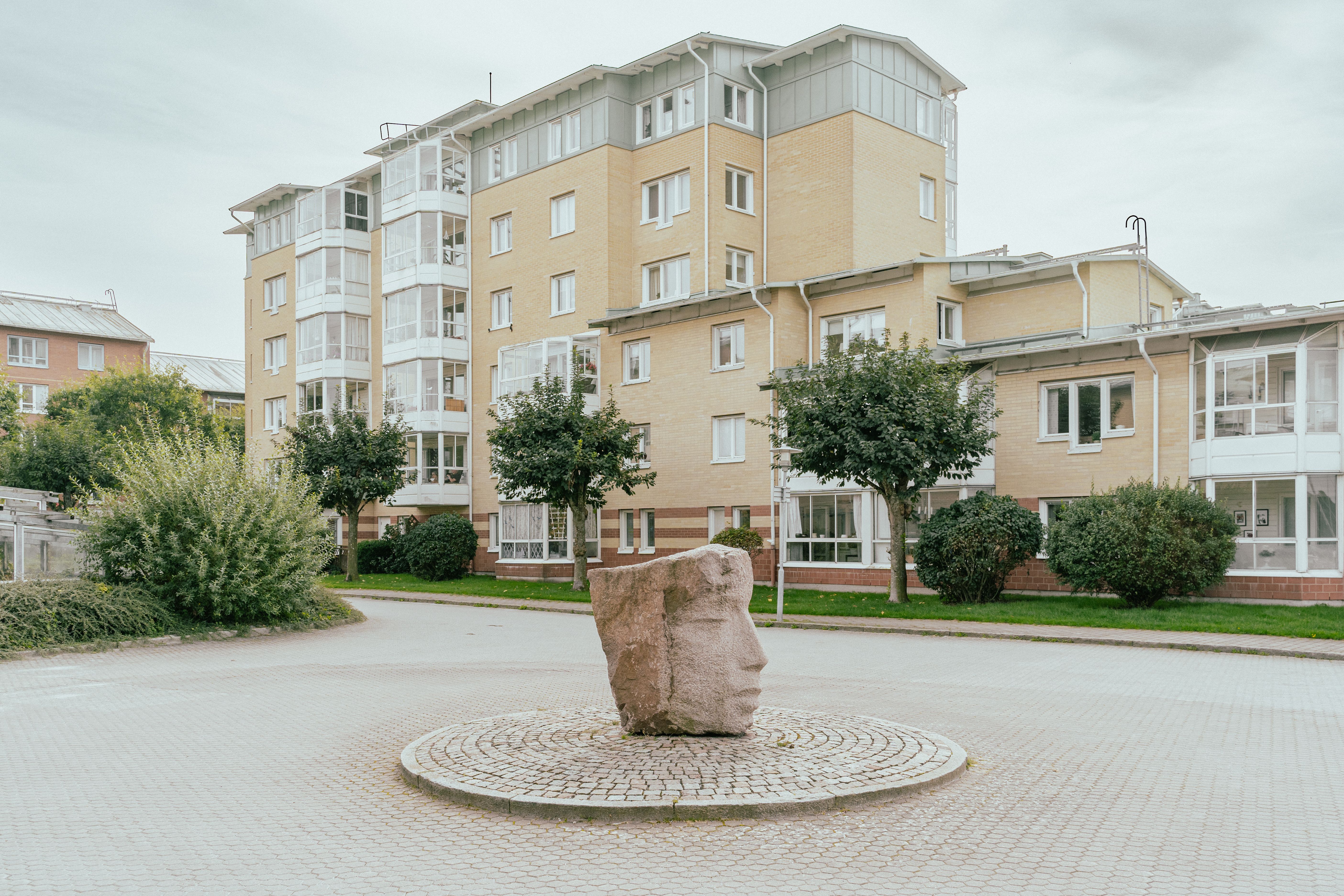 Ett ansikte uthugget ur granit står i en rondell